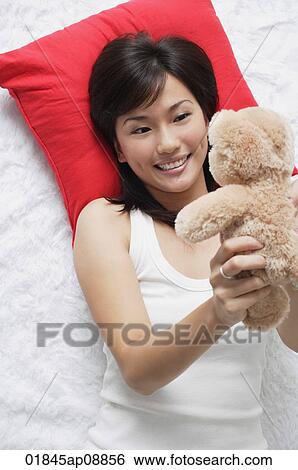Young woman playing with teddy View Large Photo Image Stock Photograph - Young woman playing with teddy. Fotosearch
