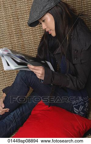 Young woman reading magazine View Large Photo Image Picture - Young woman reading magazine. Fotosearch