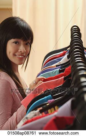 Young woman shopping for clothes View Large Photo Image Stock Image - Young woman shopping for clothes. Fotosearch