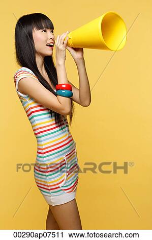 Young woman shouting through yellow megaphone View Large Photo Image Stock Image - Young woman shouting through yellow megaphone. Fotosearch