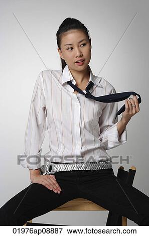Young woman sitting and playing with tie View Large Photo Image Stock Photo - Young woman sitting and playing with tie. Fotosearch