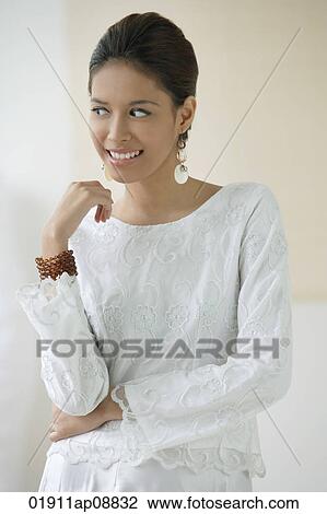 Stock Image - Young woman smiling and glancing sideways. Fotosearch