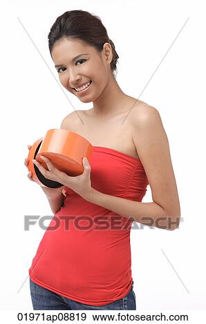 Young woman smiling at camera, holding box View Large Photo Image Stock Photo - Young woman smiling at camera, holding box. Fotosearch