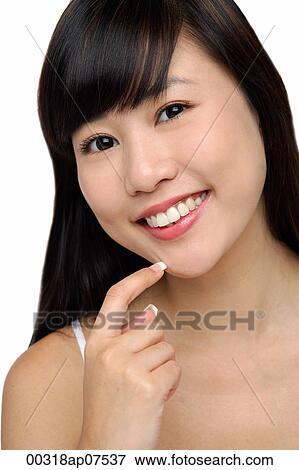 Young woman smiling, finger to chin, portrait View Large Photo Image Stock Photo - Young woman smiling, finger to chin, portrait. Fotosearch