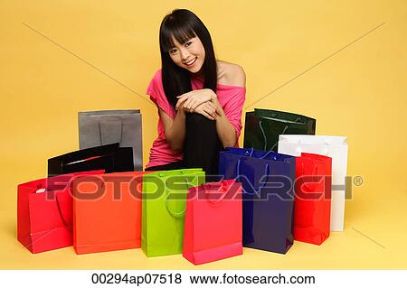 Young woman surrounded by shopping bags, kneeling on floor View Large Photo Image Stock Photo - Young woman surrounded by shopping bags, kneeling on floor. Fotosearch