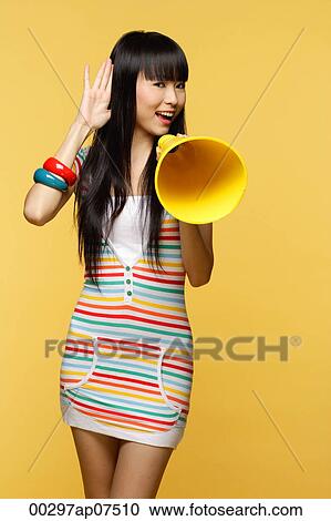 Young woman talking through yellow megaphone, hand to ear View Large Photo Image Stock Image - Young woman talking through yellow megaphone, hand to ear. Fotosearch
