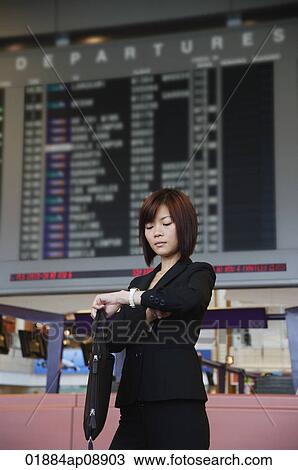 Stock Image - Young woman waiting at the airport. Fotosearch