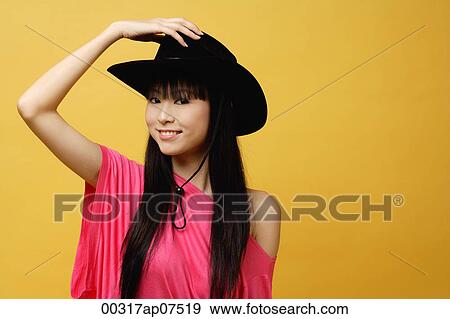 Young woman wearing black cowboy hat View Large Photo Image Stock Photo - Young woman wearing black cowboy hat. Fotosearch