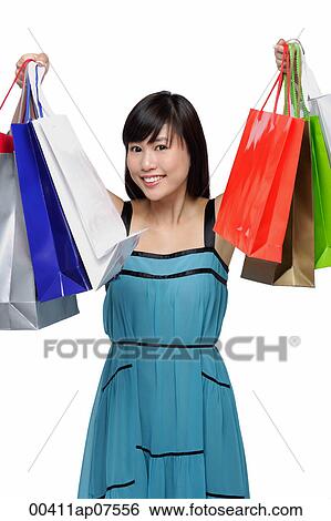 Young woman wearing blue dress and holding shopping bags up in air View Large Photo Image Stock Photograph - Young woman wearing blue dress and holding shopping bags up in air. Fotosearch