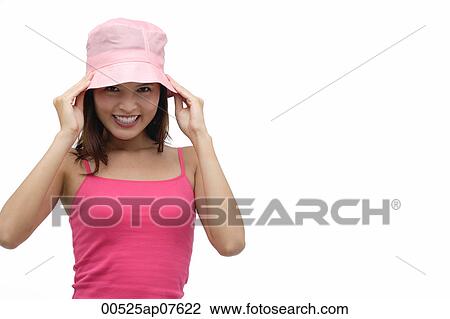 Stock Image - Young woman wearing pink hat and smiling at camera. Fotosearch
