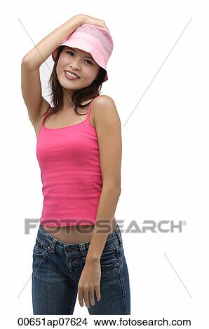 Young woman wearing pink hat with hand on head, smiling View Large Photo Image Picture - Young woman wearing pink hat with hand on head, smiling. Fotosearch