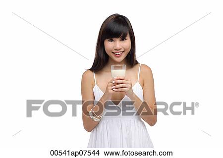Young woman wearing white dress and holding glass of milk View Large Photo Image Picture - Young woman wearing white dress and holding glass of milk. Fotosearch