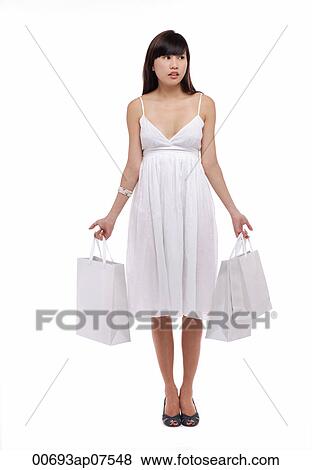 Young woman wearing white dress and holding white shopping bags View Large Photo Image Stock Photo - Young woman wearing white dress and holding white shopping bags. Fotosearch
