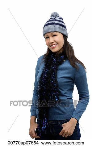 Young woman wearing winter hat and scarf, smiling at camera View Large Photo Image Picture - Young woman wearing winter hat and scarf, smiling at camera. Fotosearch