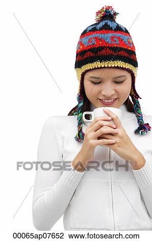 Young woman wearing winter hat and staring down at mug of hot chocolate View Large Photo Image Stock Image - Young woman wearing winter hat and staring down at mug of hot chocolate. Fotosearch