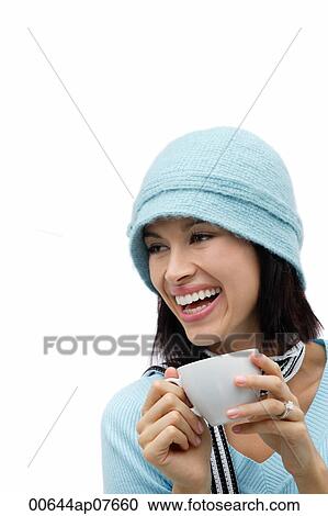 Young woman wearing wool hat and scarf, holding mug and laughing View Large Photo Image Stock Image - Young woman wearing wool hat and scarf, holding mug and laughing. Fotosearch