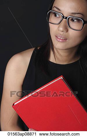 Young woman with book looking into distance View Large Photo Image Stock Image - Young woman with book looking into distance. Fotosearch