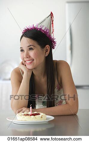 Picture - Young woman with cake smiling. Fotosearch