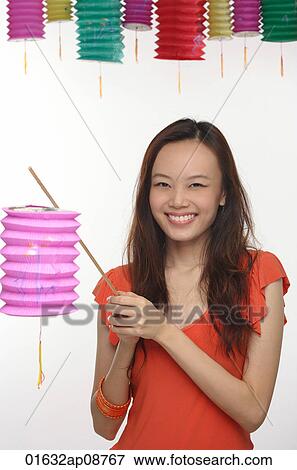 Stock Photo - Young woman with Chinese lantern smiling at camera. Fotosearch