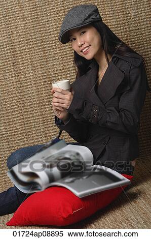 Young woman with cup smiling at camera View Large Photo Image Stock Photography - Young woman with cup smiling at camera. Fotosearch