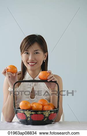 Young woman with fruit smiling at camera View Large Photo Image Picture - Young woman with fruit smiling at camera. Fotosearch