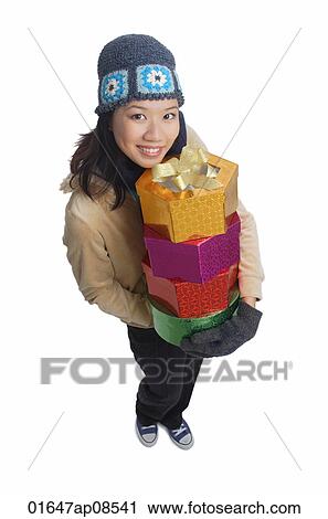 Young woman with gift boxes, smiling at camera View Large Photo Image Stock Image - Young woman with gift boxes, smiling at camera. Fotosearch