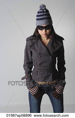 Stock Photograph - Young woman with sunglasses and winter clothes. Fotosearch