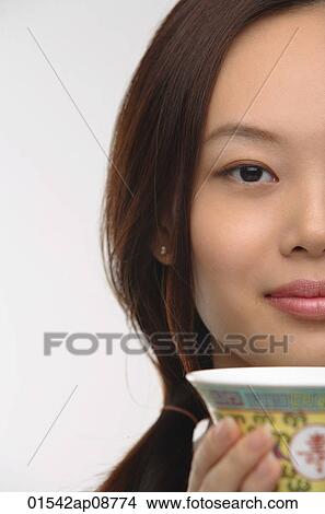 Young woman with traditional tea cup looking at camera View Large Photo Image Picture - Young woman with traditional tea cup looking at camera. Fotosearch