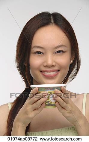 Young woman with traditional tea cup smiling at camera View Large Photo Image Stock Image - Young woman with traditional tea cup smiling at camera. Fotosearch