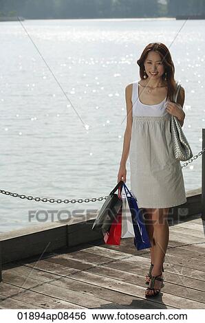Young women carrying shopping bags View Large Photo Image Stock Photograph - Young women carrying shopping bags. Fotosearch