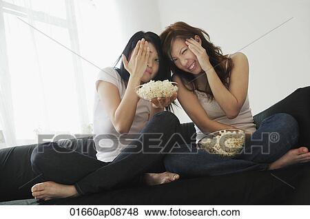 Young women enjoying popcorn View Large Photo Image Stock Photo - Young women enjoying popcorn. Fotosearch