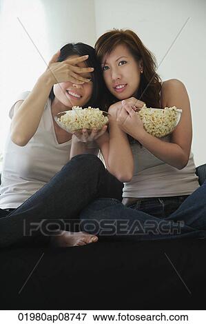 Young women enjoying popcorn View Large Photo Image Stock Photo - Young women enjoying popcorn. Fotosearch