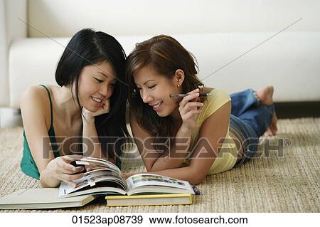 Young women lying on the floor reading book View Large Photo Image Stock Photo - Young women lying on the floor reading book. Fotosearch