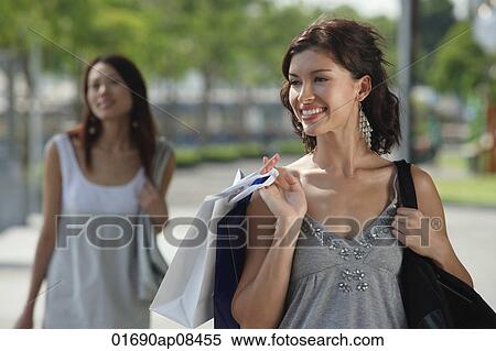 Stock Photography - Young women shopping together. Fotosearch
