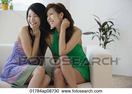 Young women sitting on sofa View Large Photo Image Stock Image - Young women sitting on sofa. Fotosearch