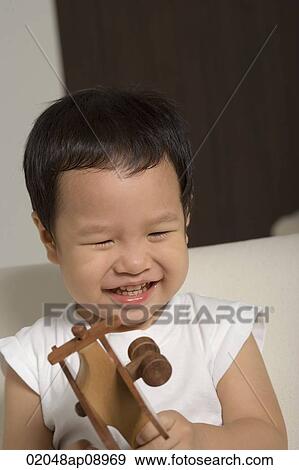 Baby boy playing with wooden toy plane View Large Photo Image Stock Photo - Baby boy playing with wooden toy plane. Fotosearch