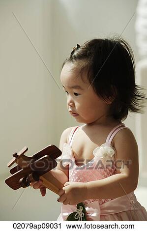 Baby girl with toy plane in hands View Large Photo Image Stock Image - Baby girl with toy plane in hands. Fotosearch
