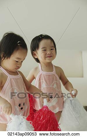Baby girls with pom-poms View Large Photo Image Stock Image - Baby girls with pom-poms. Fotosearch