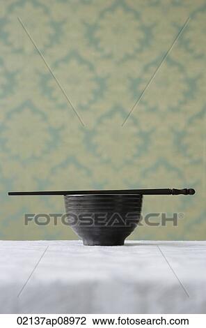 Stock Image - Bowl with chopsticks. Fotosearch
