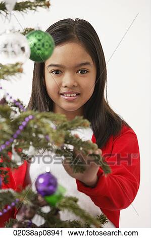 Girl by the Christmas tree, looking at camera View Large Photo Image Stock Image - Girl by the Christmas tree, looking at camera. Fotosearch