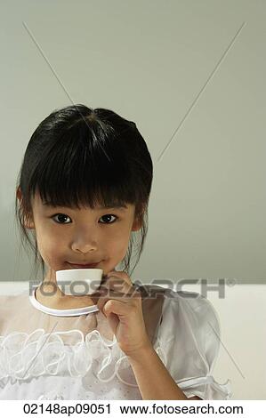 Girl drinking from tiny cup View Large Photo Image Stock Image - Girl drinking from tiny cup. Fotosearch