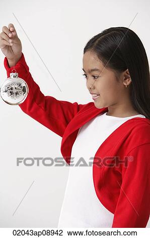 Girl holding up Christmas decoration View Large Photo Image Stock Image - Girl holding up Christmas decoration. Fotosearch