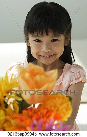 Stock Photography - Girl with flowers smiling at camera. Fotosearch