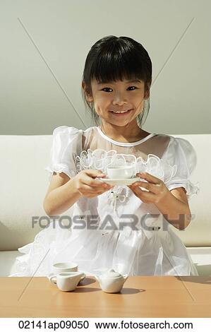 Girl with tea set in hands smiling at camera View Large Photo Image Stock Image - Girl with tea set in hands smiling at camera. Fotosearch