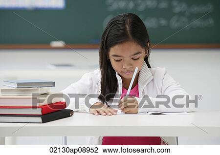 Girl writing and sitting at school desk View Large Photo Image Stock Image - Girl writing and sitting at school desk. Fotosearch
