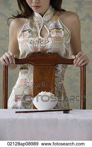 Young woman behind chair with bowl of rice on table View Large Photo Image Stock Photo - Young woman behind chair with bowl of rice on table. Fotosearch