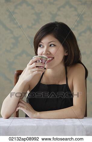 Young woman drinking tea looking sideway View Large Photo Image Stock Image - Young woman drinking tea looking sideway. Fotosearch