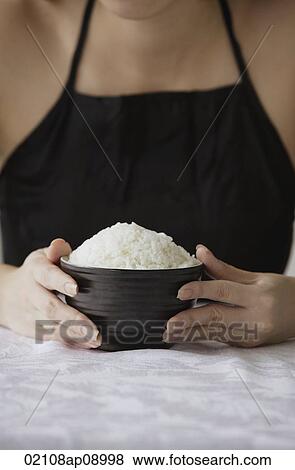 Young woman holding bowl of rice with both hands View Large Photo Image Stock Photo - Young woman holding bowl of rice with both hands. Fotosearch