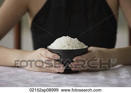 Young woman holding bowl of rice with both hands View Large Photo Image Stock Photo - Young woman holding bowl of rice with both hands. Fotosearch
