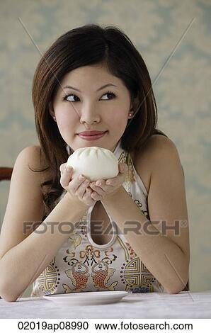 Young woman holding chinese bun with both hands View Large Photo Image Stock Image - Young woman holding chinese bun with both hands. Fotosearch